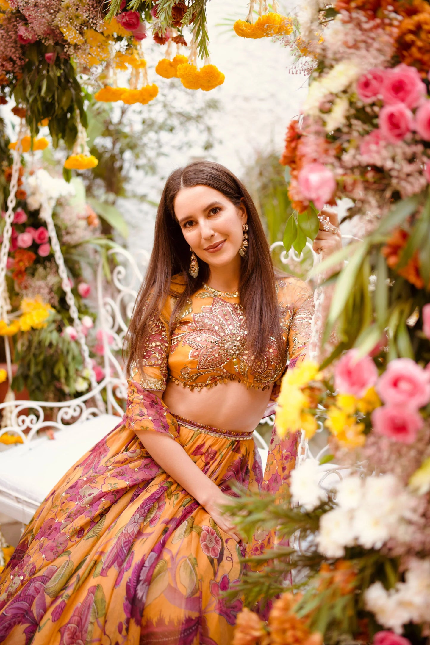 Bright lehenga fashion look captured in a romantic floral installation setting