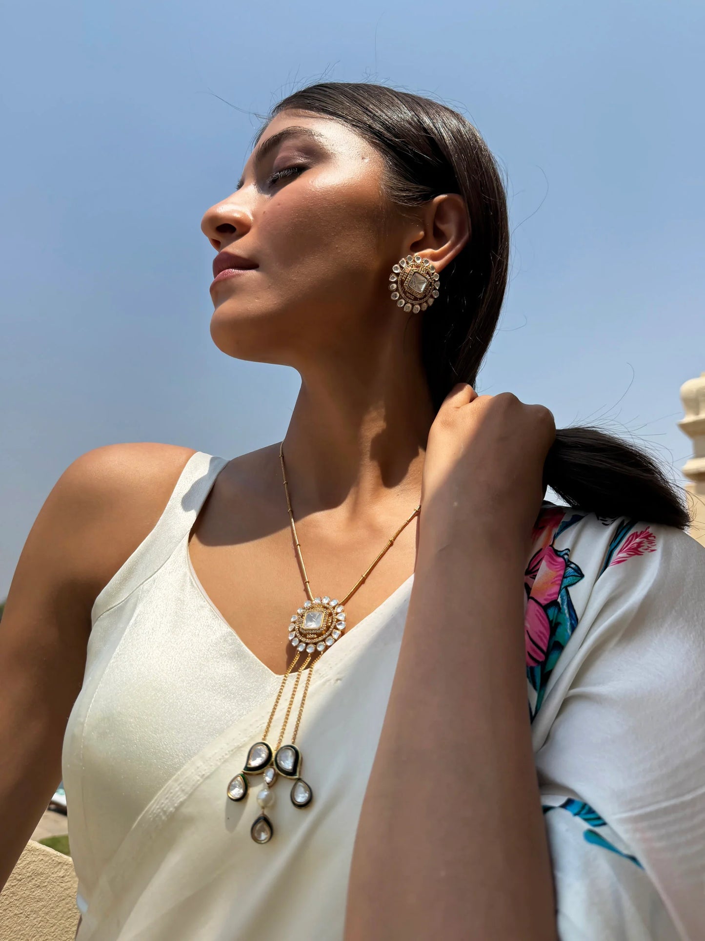 Indoor fashion portrait of a man in light outfit sitting in a curated modern living room
