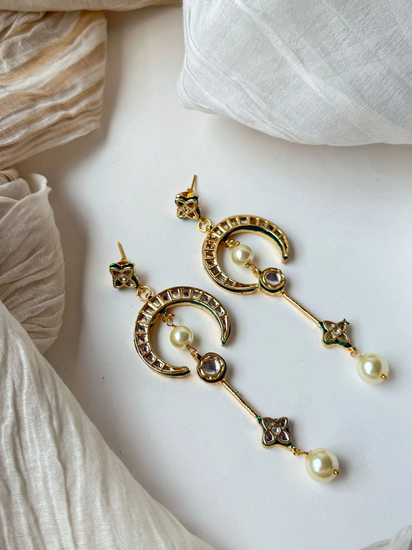 Stylish gold earrings with crescent design, pearl hangings, and detailed craftsmanship