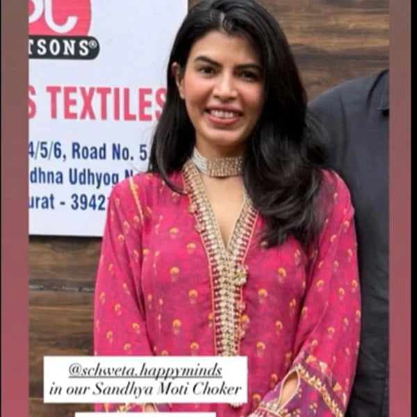Refined portrait capturing a woman adjusting a structured diamond collar necklace, emphasizing brilliance and symmetry.