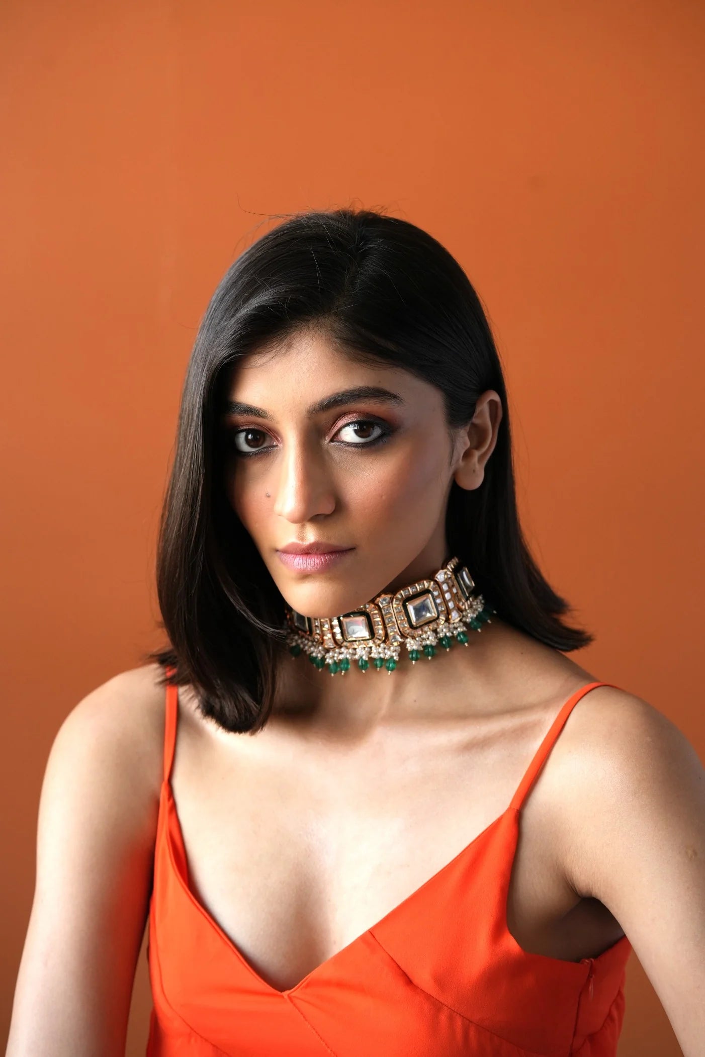 Sophisticated portrait featuring a woman in a modern black saree look with a structured choker and minimal styling.