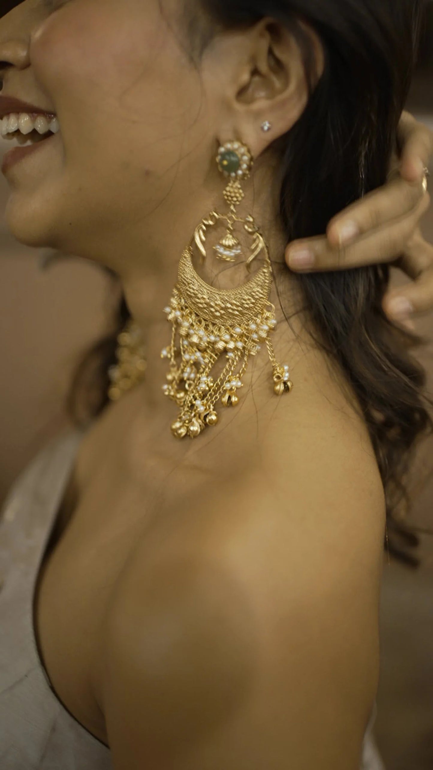 Red lehenga outfit with gold embroidery and statement jewelry on model