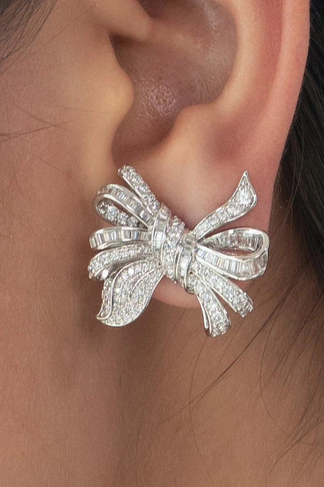 Sterling silver bow earrings with pavé stone detailing and sculpted ribbon design for festive and party wear