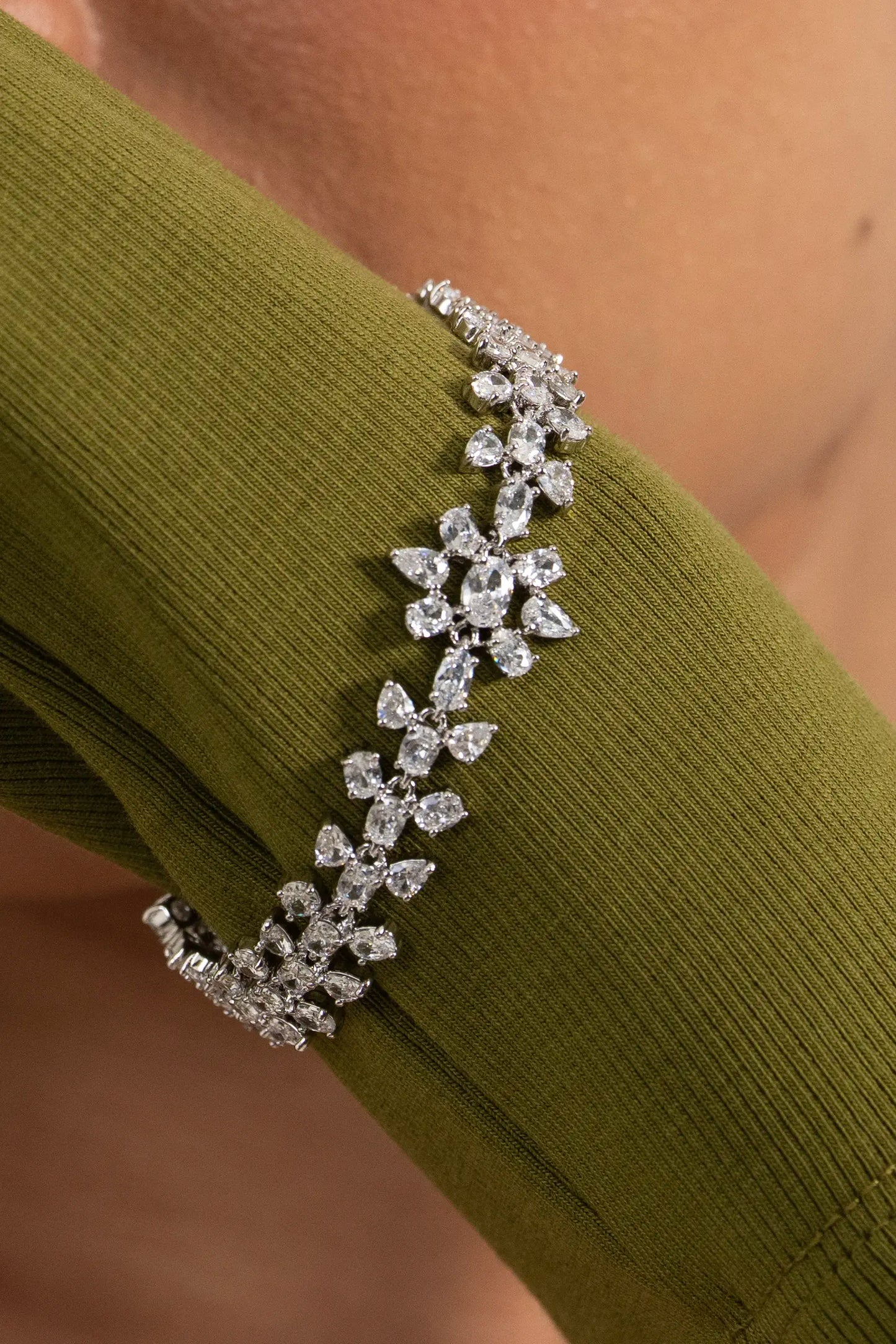 Close-up of a woman wearing a diamond daisy cluster bracelet, delicate floral design with premium styling