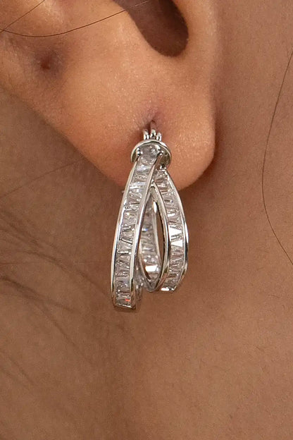 Silver hoop earring with baguette-cut diamonds on ear, showcasing modern luxury jewelry style