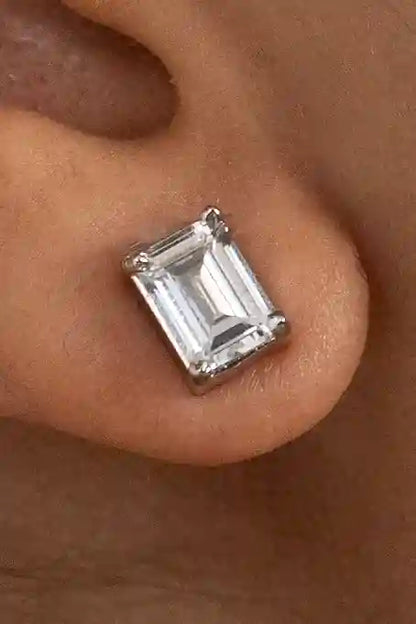 Close-up of an emerald cut diamond stud earring on ear, elegant women’s luxury jewelry design