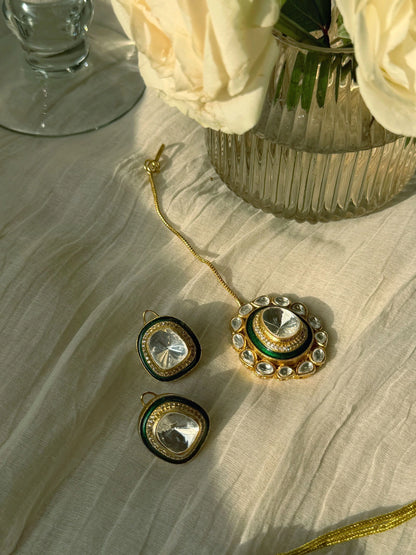 Close-up of ornate gold choker necklace with green enamel and crystal stones on display bust
