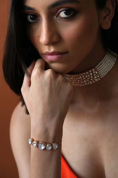 Fashion portrait showcasing a woman adorned with fine diamond jewelry, styled with a modern outfit in a clean studio setting.

