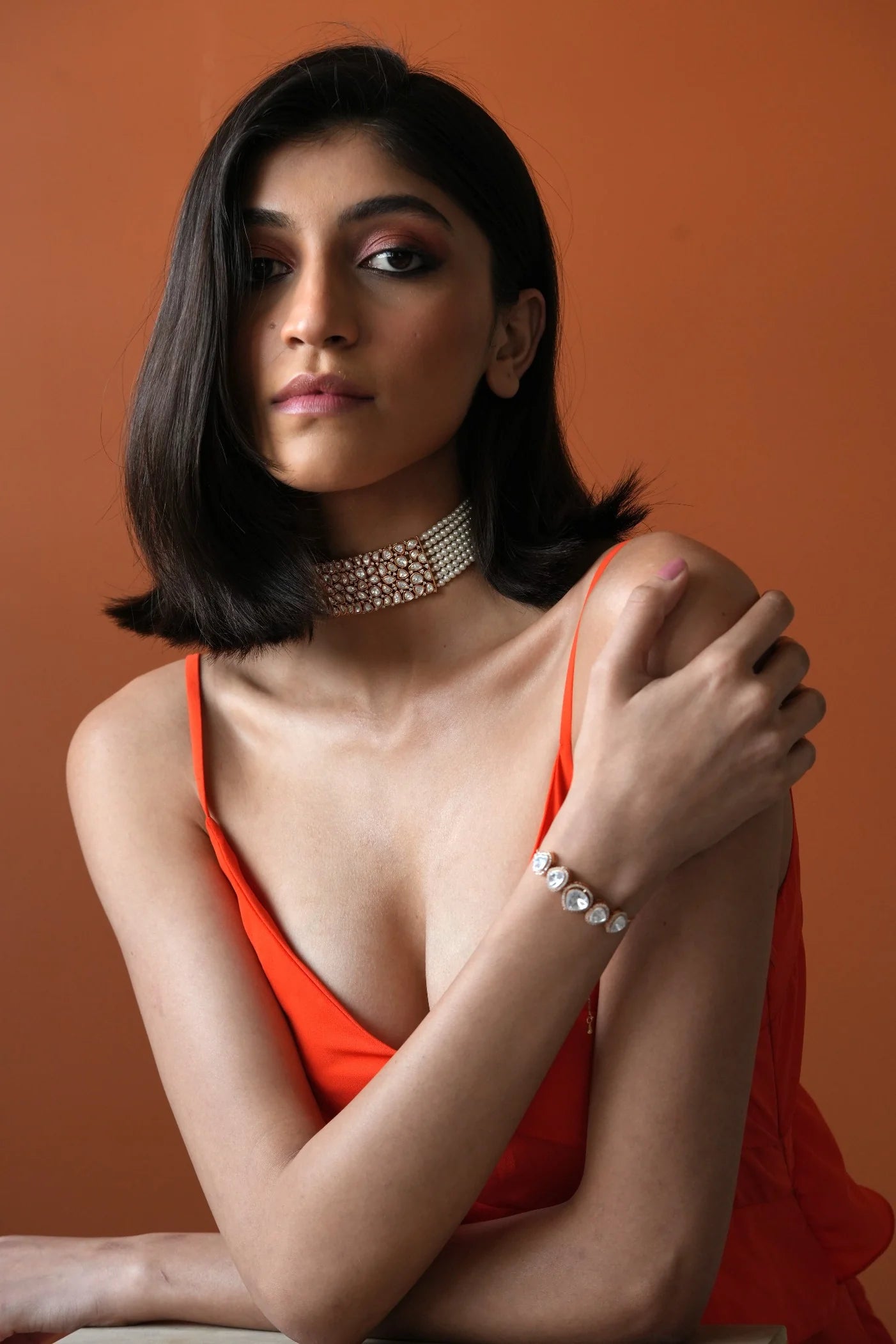Luxury jewelry styling shot highlighting multiple diamond accessories on a woman in a polished, minimal background.
