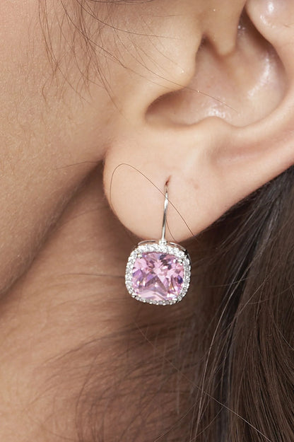 Sophisticated close-up of a woman wearing a soft pink crystal drop earring, emphasizing a clean and modern aesthetic.
