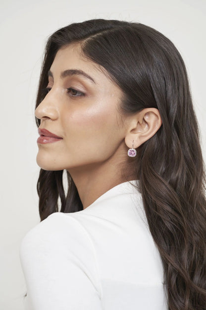 Detailed profile view highlighting a single pink gemstone earring with a refined setting and polished finish.
