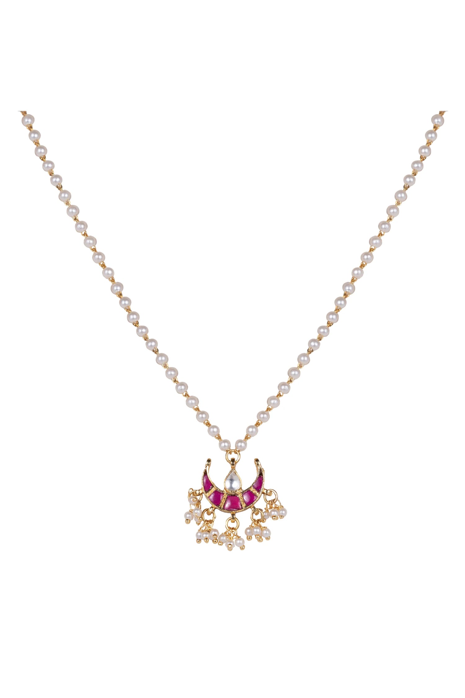 Detailed jewelry shot of a traditional-style necklace with gold beads, pearls, and a vibrant red pendant resting on textured fabric.
