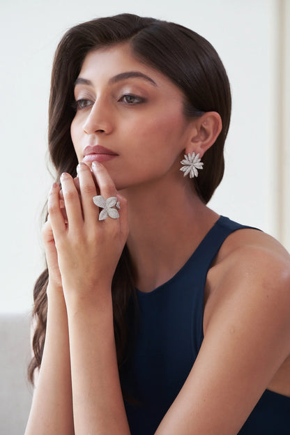 Fine jewelry flower ring featuring four shimmering diamond petals on a white gold band, worn on hand.
