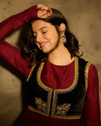 Beauty shot highlighting a woman’s joyful expression paired with detailed gold earrings and a textured red ensemble.
