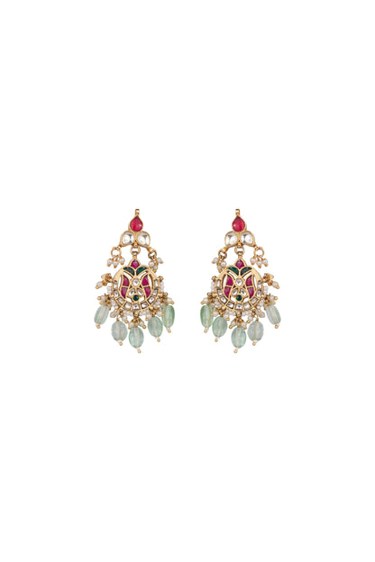 Artistic close-up of a woman in warm light wearing statement earrings with layered detailing and a festive outfit.
