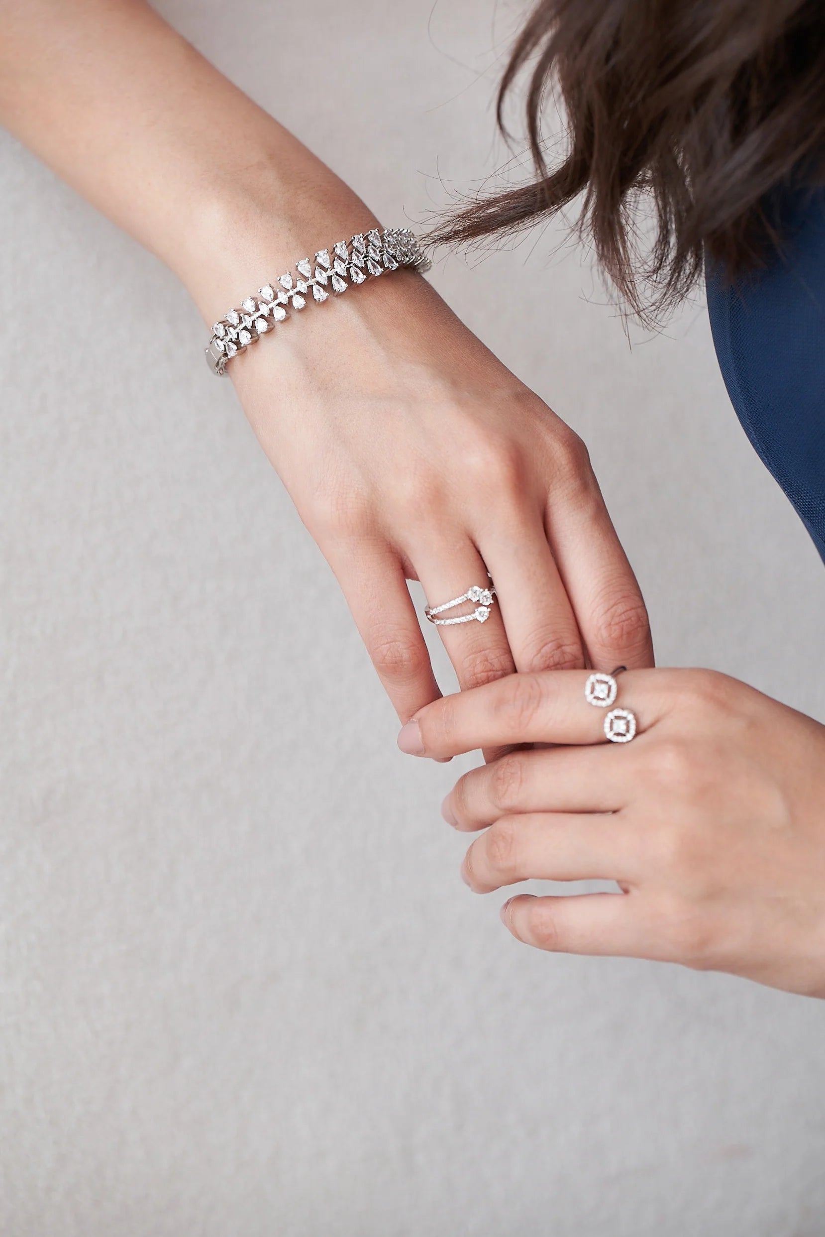 Elegant diamond bracelet with pear-cut stones arranged in a floral vine design, worn on wrist in a luxury jewelry close-up.
