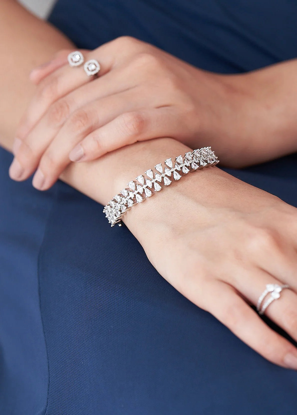Fine jewelry bracelet showcasing pear-cut diamonds in a continuous botanical pattern, captured in a detailed wrist close-up.
