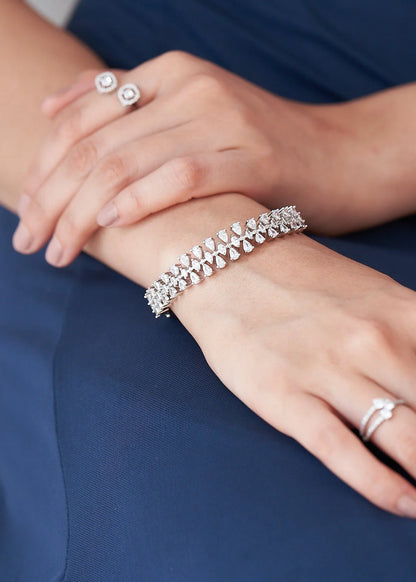 Fine jewelry bracelet showcasing pear-cut diamonds in a continuous botanical pattern, captured in a detailed wrist close-up.
