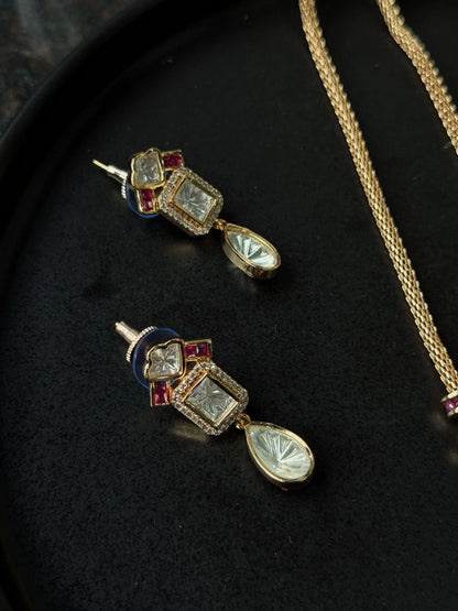 Stylish jewelry set featuring gold necklace with teardrop pendant and red gemstone accents
