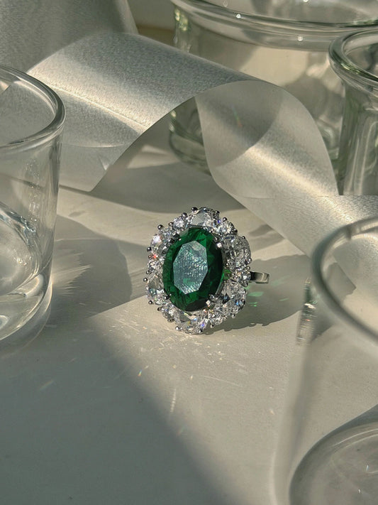 Luxury cocktail ring with green gemstone and diamond detailing in soft aesthetic setup
