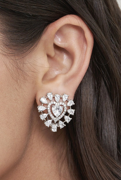 Elegant portrait detail highlighting a heart motif diamond earring surrounded by a burst of sparkling stones on the ear.
