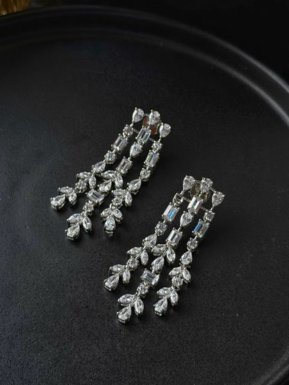 Luxury long drop earrings with baguette and pear-shaped crystals in detailed close-up
