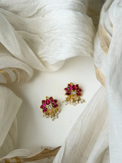 Designer gold drop earrings with circular red detailing and crystal embellishments
