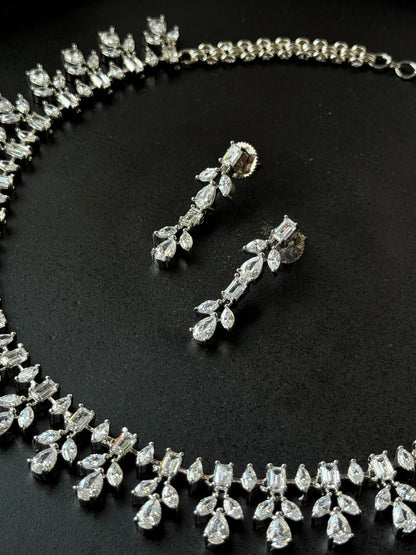 Premium silver jewelry set featuring intricate crystal necklace and dangling earrings
