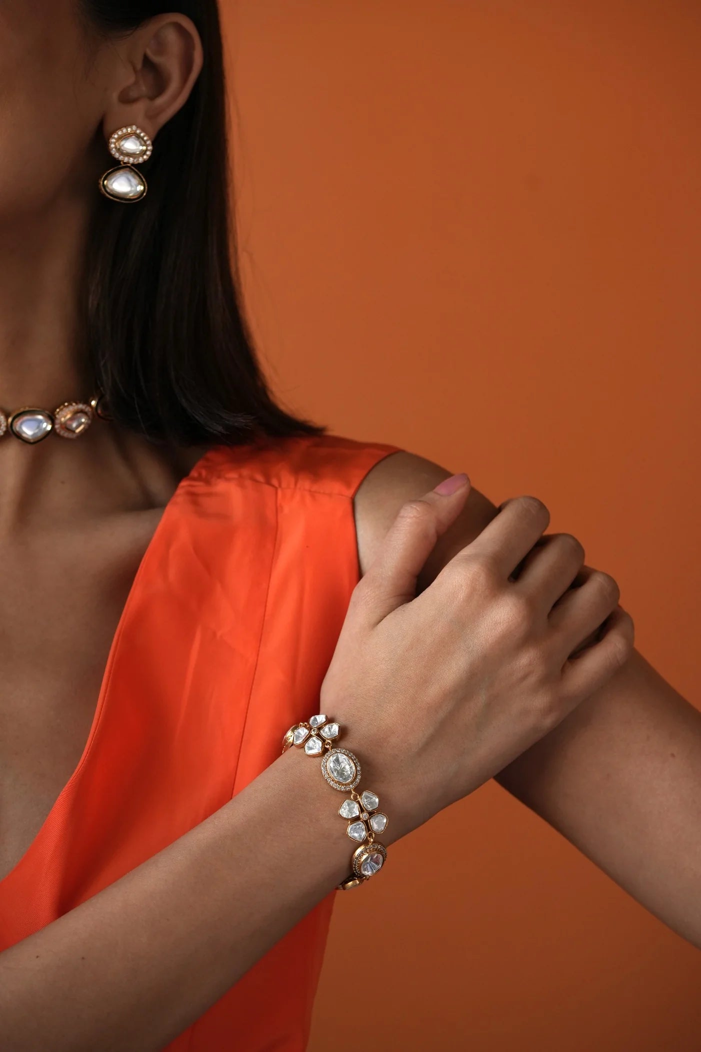 Elegant woman wearing a statement diamond choker, styled with a soft neutral outfit and minimal background.
