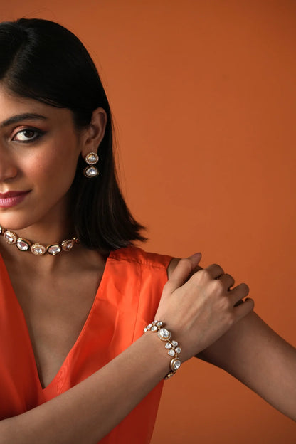 Close-up portrait of a woman adjusting a sparkling multi-row diamond choker necklace with both hands.

