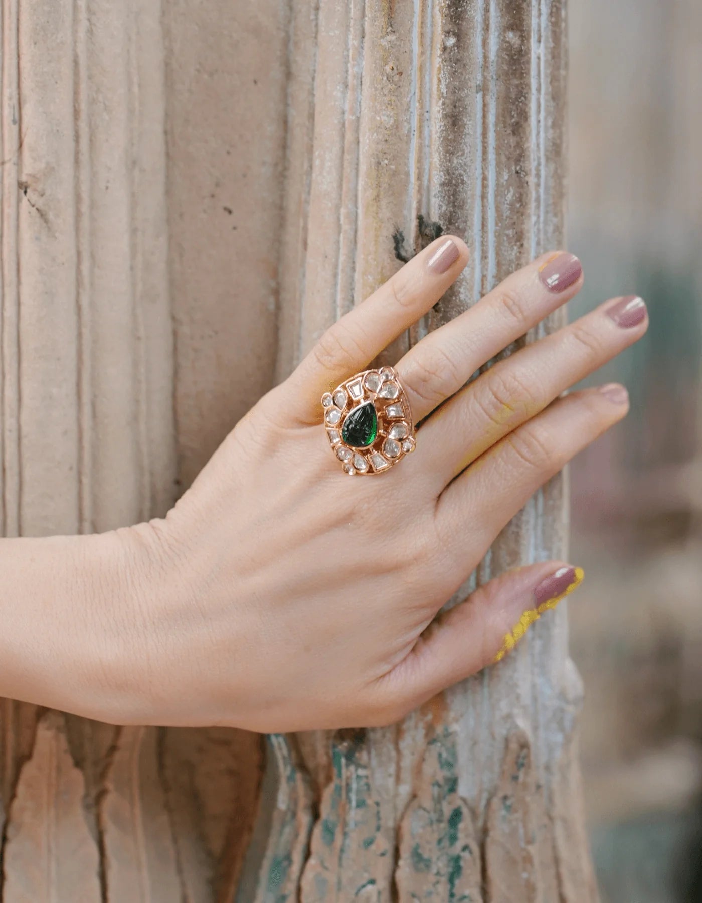 Refined beauty portrait focusing on a woman’s expressive pose with highlighted jewelry including drop earrings and a gemstone ring.
