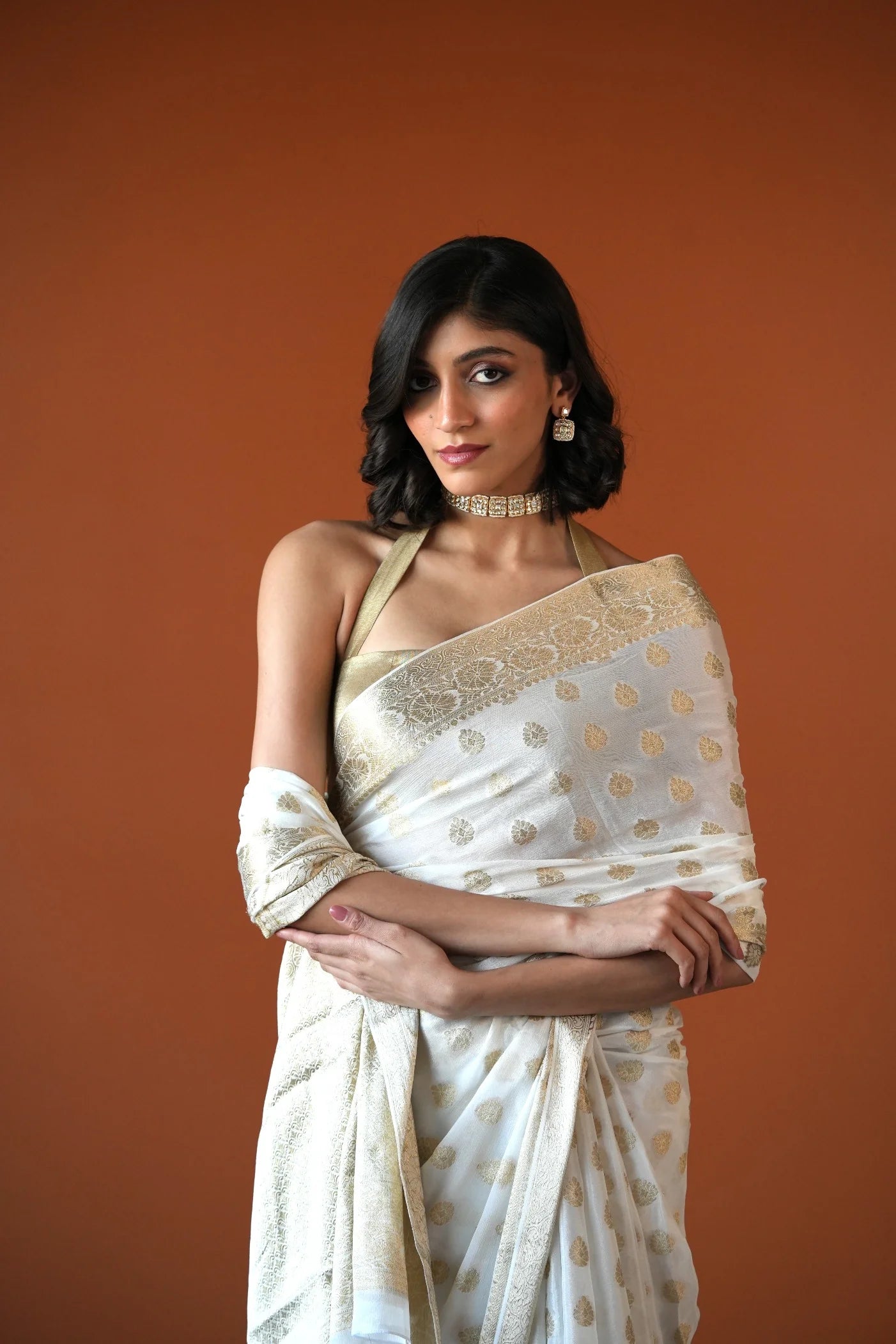 Beauty shot highlighting a woman’s radiant expression paired with a bold choker necklace and intricate drop earrings.
