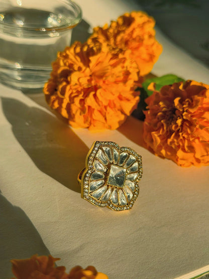 Luxury floral gold ring with crystal detailing styled with marigold flowers and soft light
