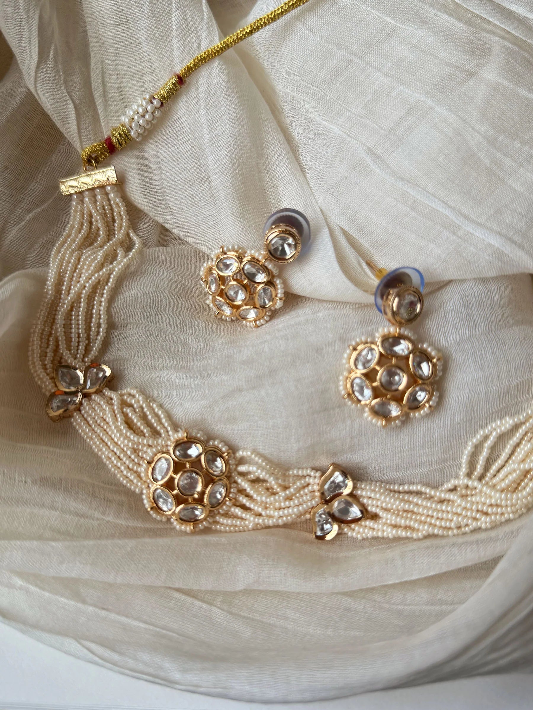 High-end bridal jewelry featuring kundan choker with intricate stonework and drop pendant
