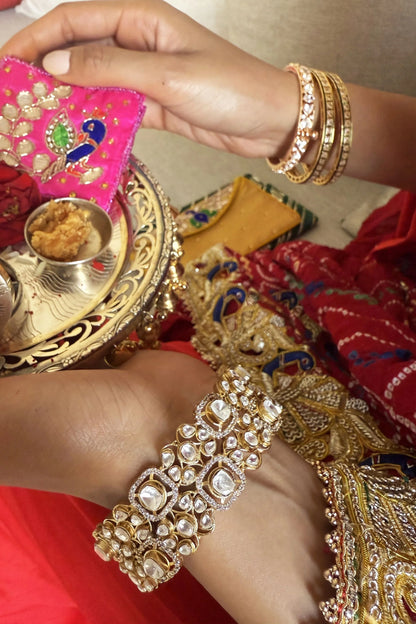 Indian ethnic wear styling with embroidered blouse, peach drape, and elegant gold jewelry accessories
