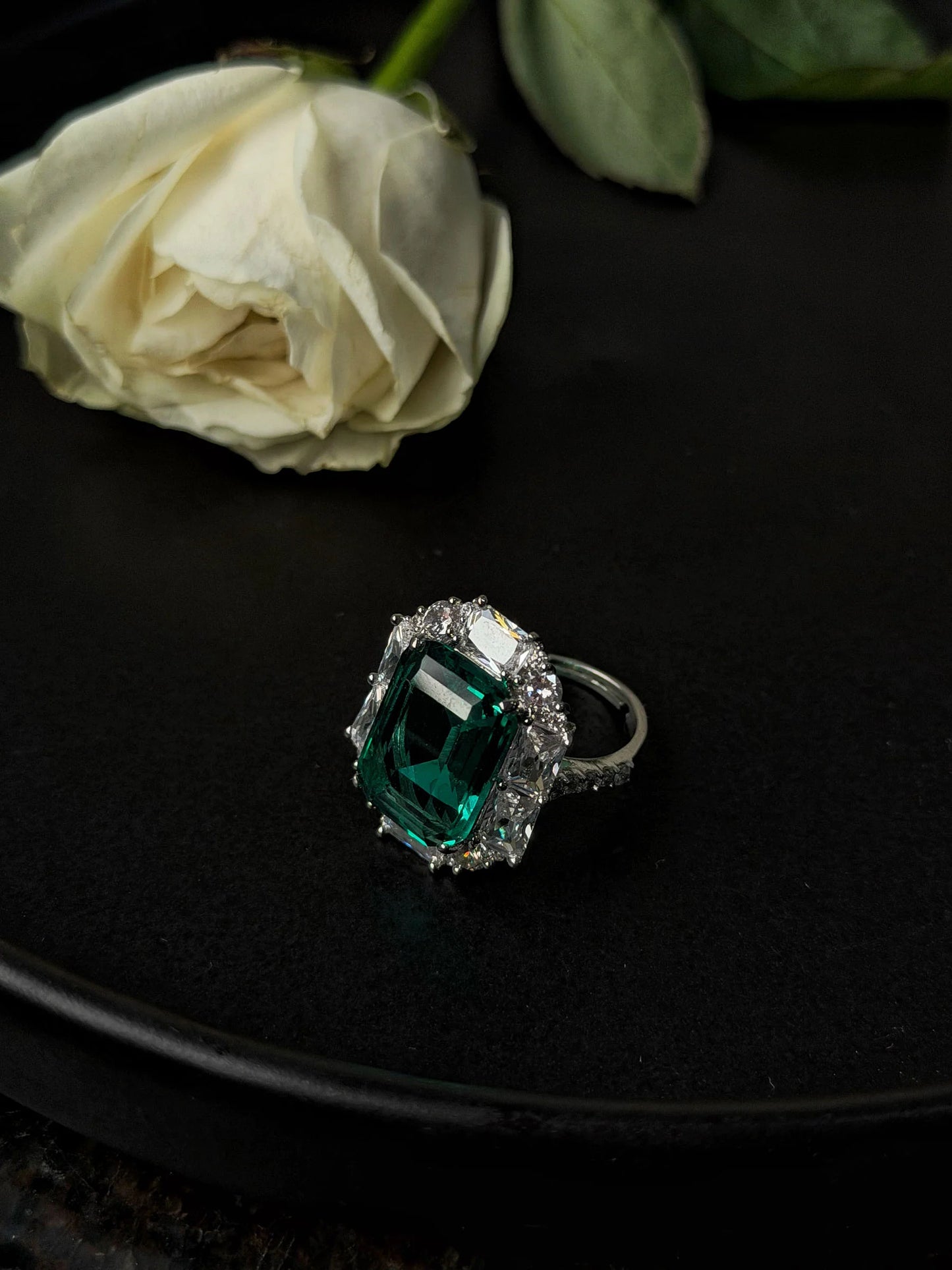 High-end green gemstone ring with diamond setting in minimal elegant background
