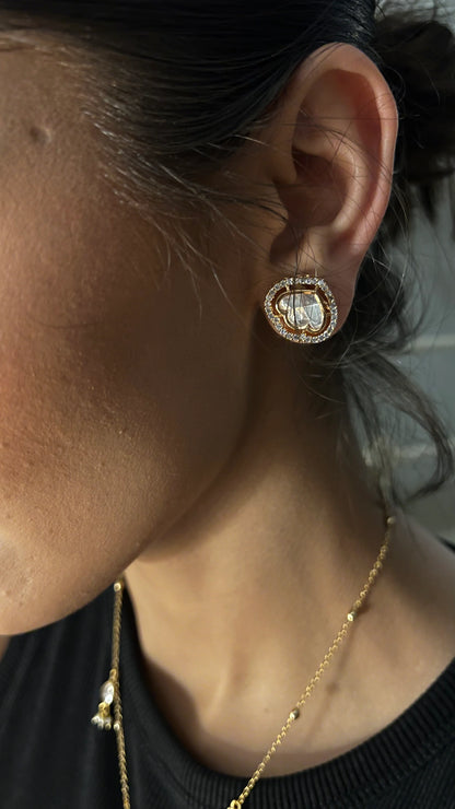 Fine accessory shot of a delicate layered necklace with a polished drop pendant resting against a dark ribbed fabric.
