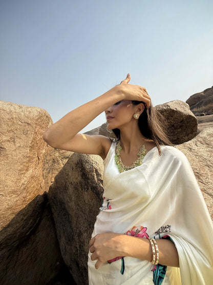 Sophisticated portrait of a woman resting her face on her hand, showcasing intricate rings and a bracelet in a heritage setting.
