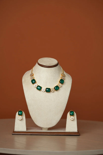 Sophisticated portrait crop focusing on a vibrant green gem earring paired with clustered pearl accents and warm skin tones.
