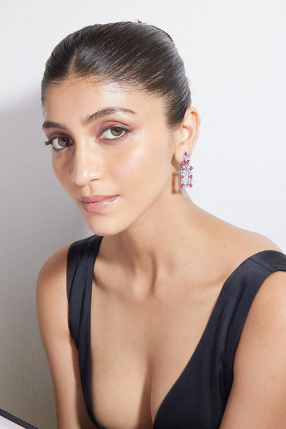 Luxury pink crystal dangle earrings on model with smooth skin and minimalist black dress portrait
