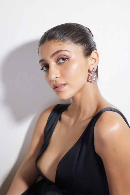 High-end jewelry product image featuring pink drop earrings worn by woman with polished makeup look

