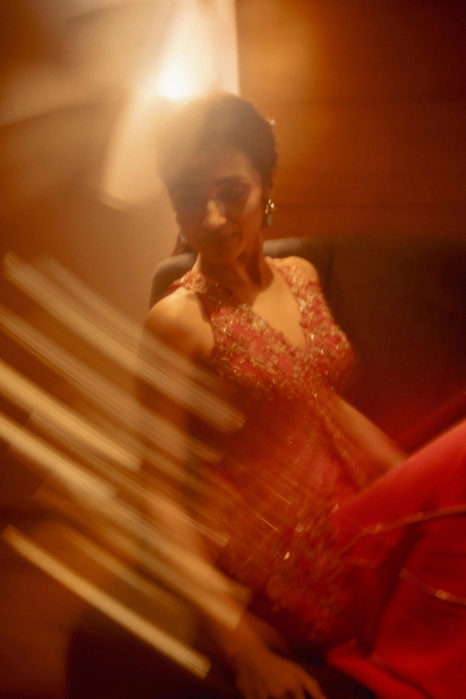 Beauty portrait of a woman in a red ethnic ensemble with statement earrings and soft warm lighting
