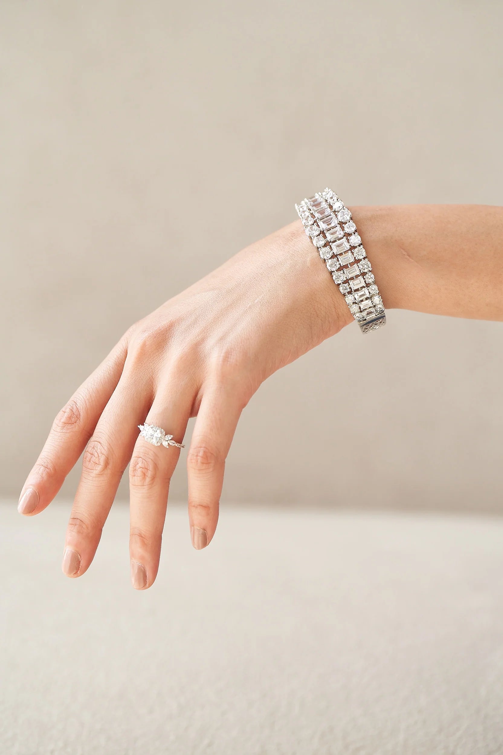 Fine diamond ring with a soft cushion center stone and tapered marquise details, creating a floral-inspired silhouette.
