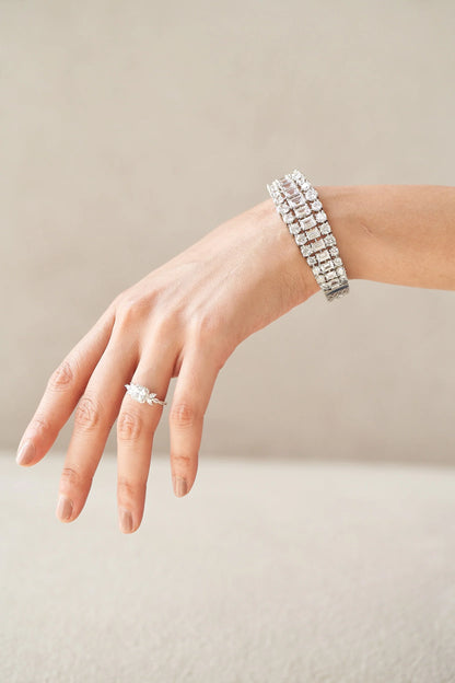 Fine diamond ring with a soft cushion center stone and tapered marquise details, creating a floral-inspired silhouette.
