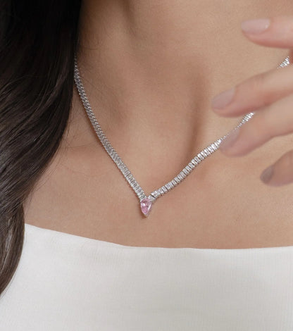 Close-up portrait featuring a woman in a minimal white outfit showcasing coordinated diamond jewelry in a refined, modern style.
