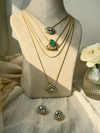 Luxury multi-layer gold chains with green gemstone centerpiece and kundan detailing
