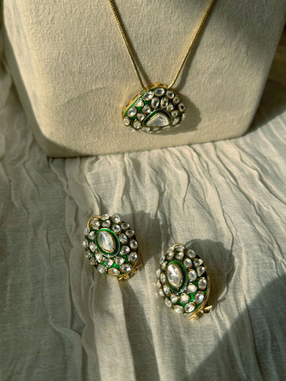 Elegant layered necklace with emerald pendant and matching kundan earrings display
