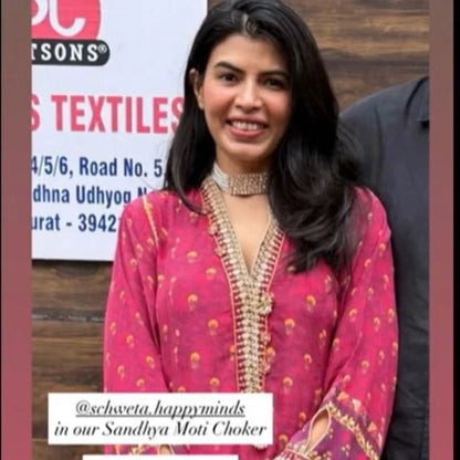 Refined portrait capturing a woman adjusting a structured diamond collar necklace, emphasizing brilliance and symmetry.
