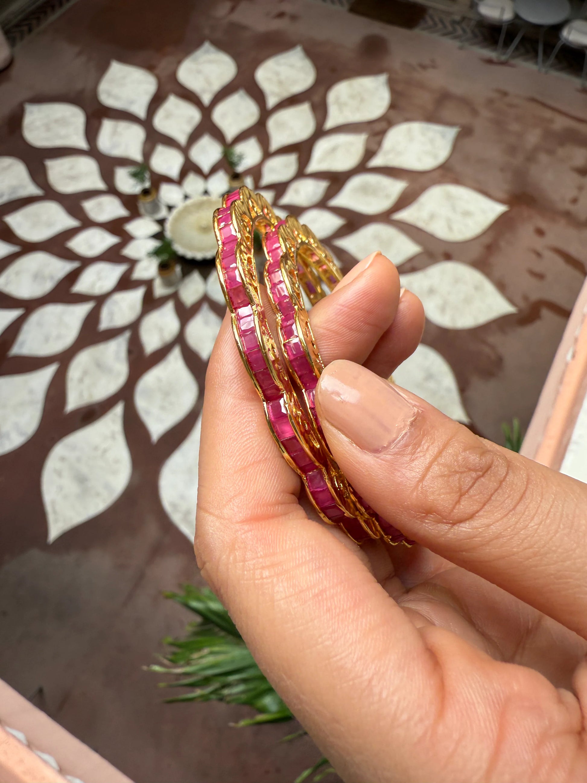 Indian woman in red kurta placing flowers on decorated pooja setup with marigold garlands
