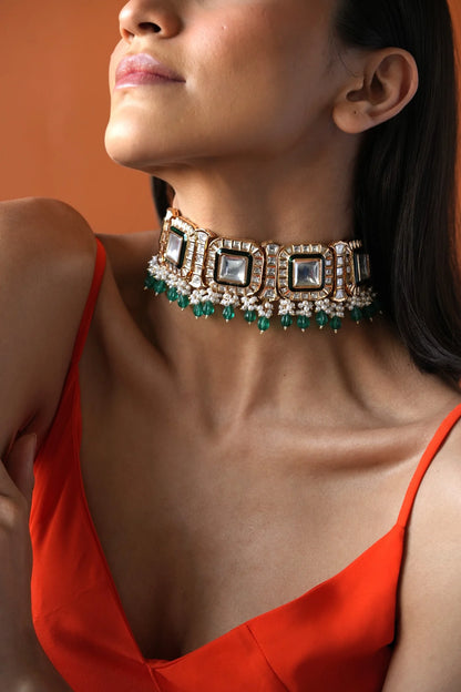 Elegant fashion shot of a woman in a sleek black outfit paired with a bold, multi-stone choker necklace.

